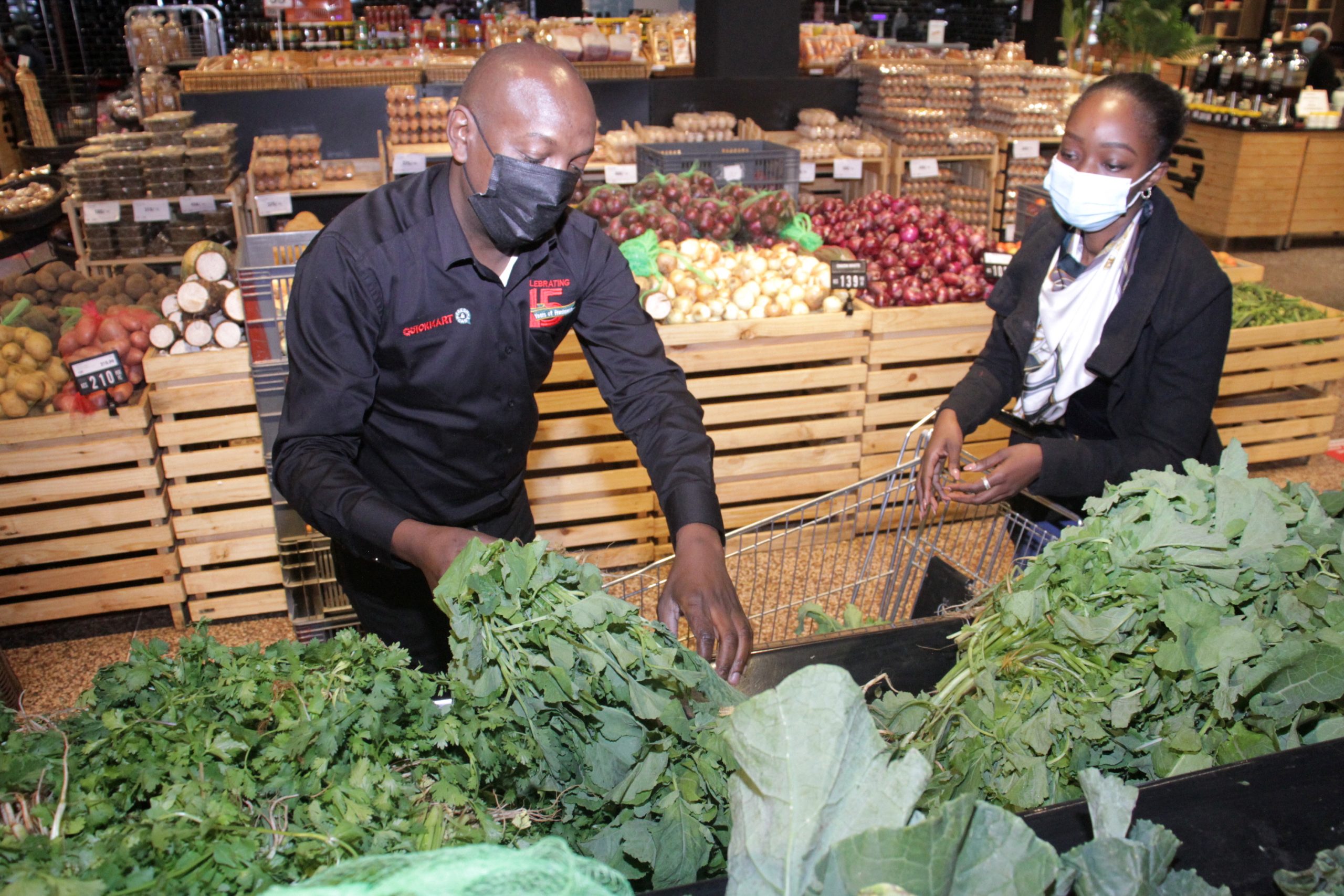 Quickmart-CEO-Peter-Kangiri-assists-a-customer-Vanessa-Amollo-at-the-retailers-Kilimani-branch-as-the-company-marked-15-years-anniversary.(photo:courtesy